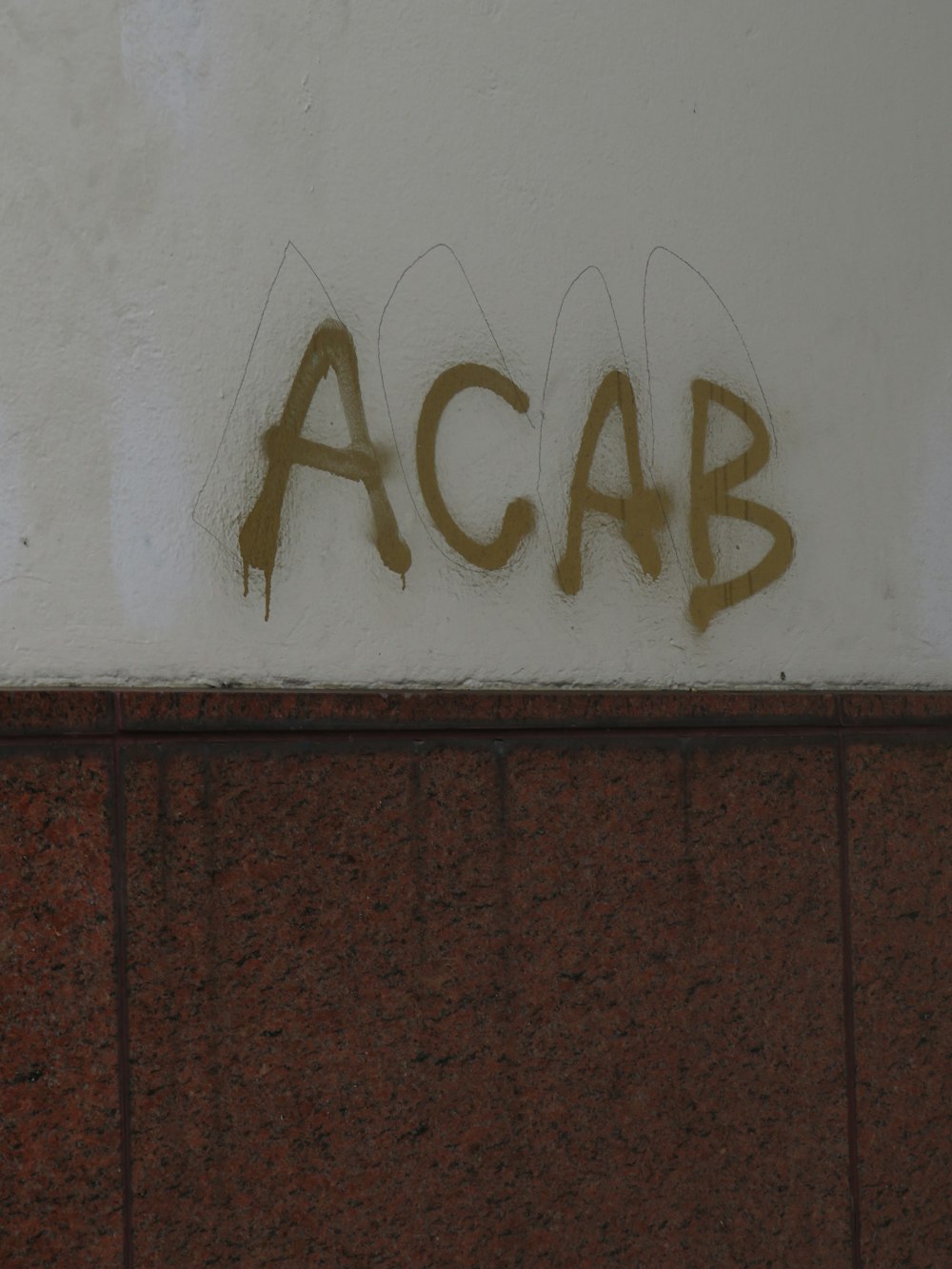graffiti on the side of a building reads acab