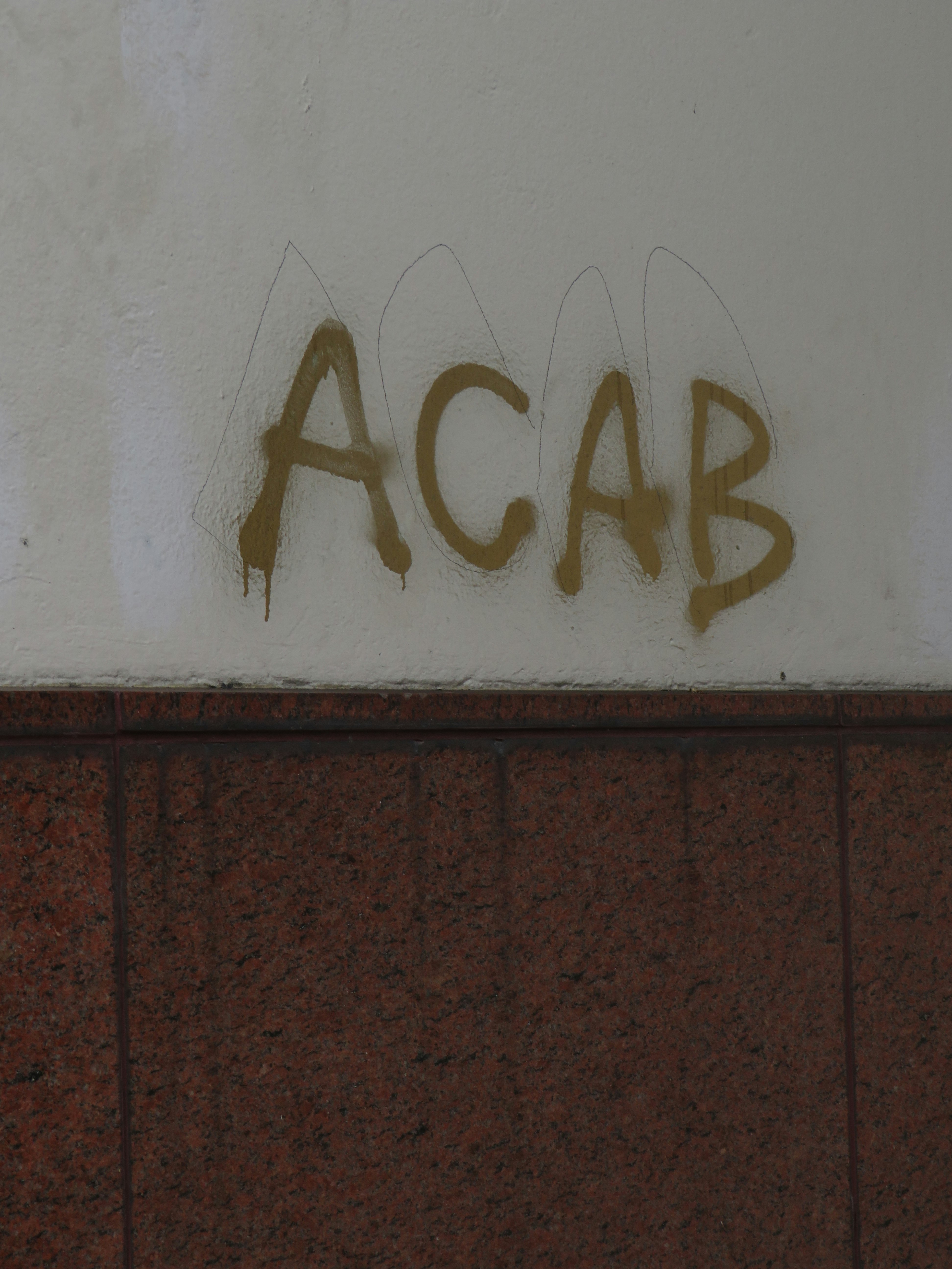 ACAB "All Cops Are Bad/Bastards" spray-painted on the wall.