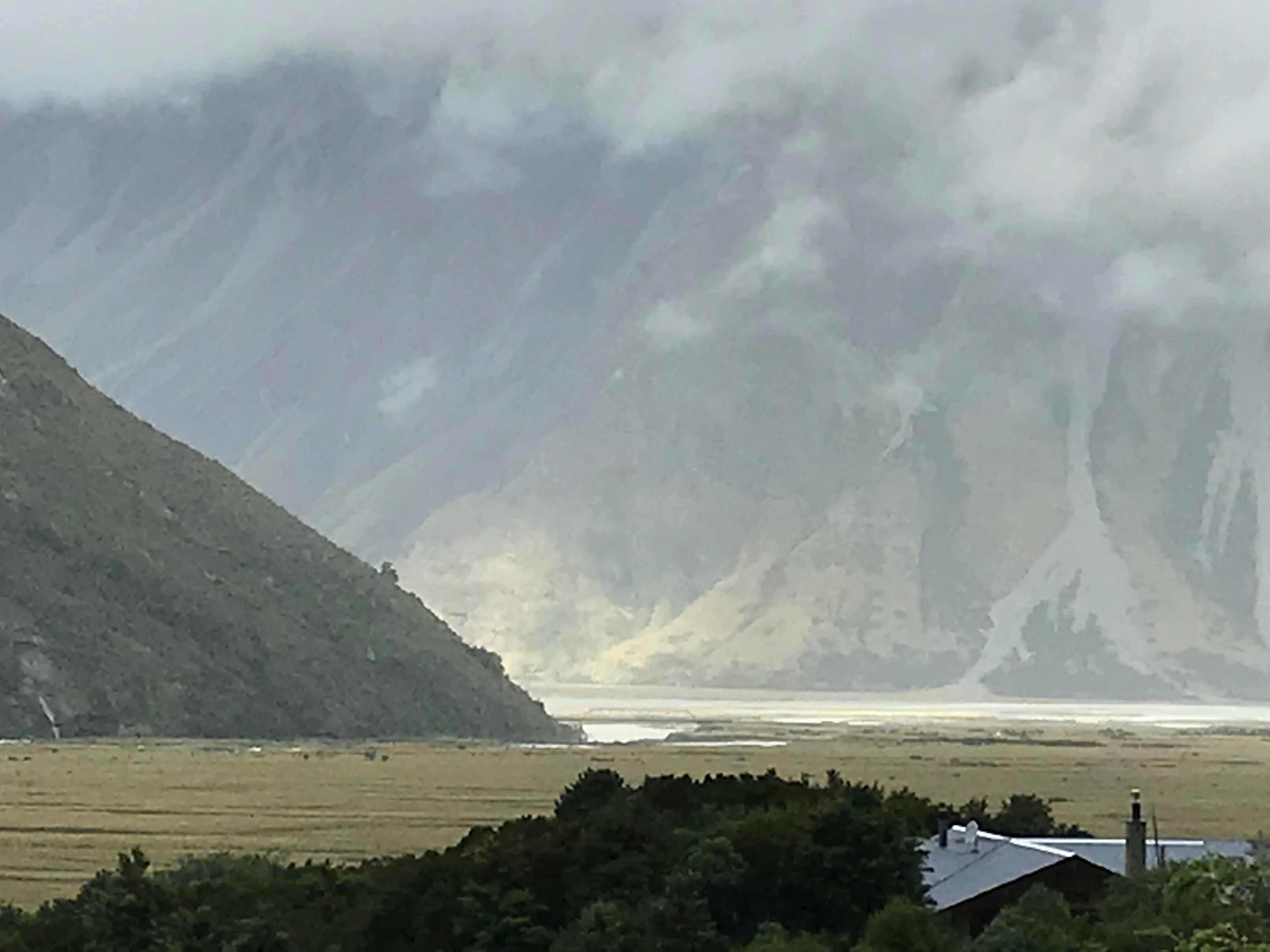 a view of a mountain range with a house in the foreground