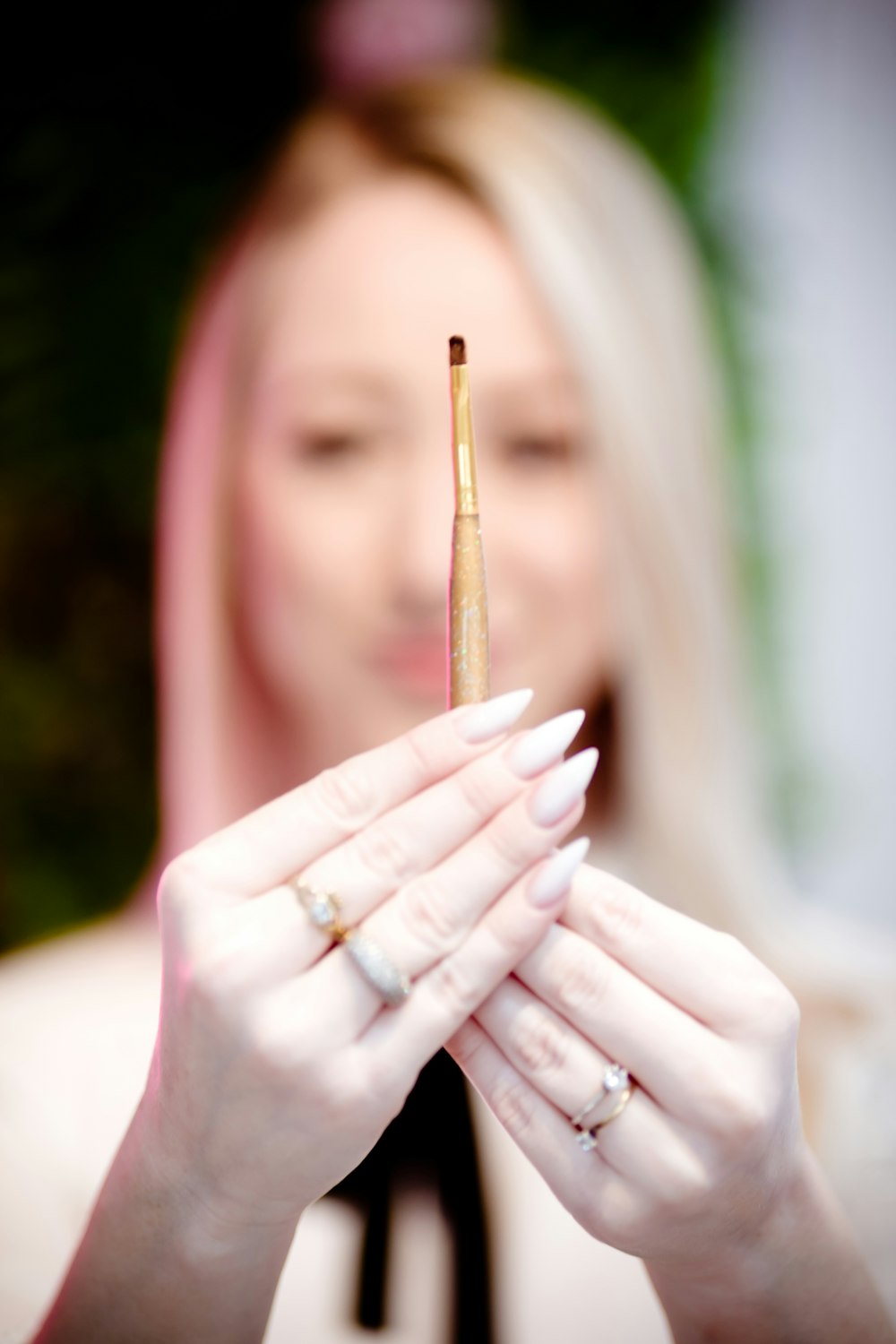 a woman holding a cigarette in front of her face