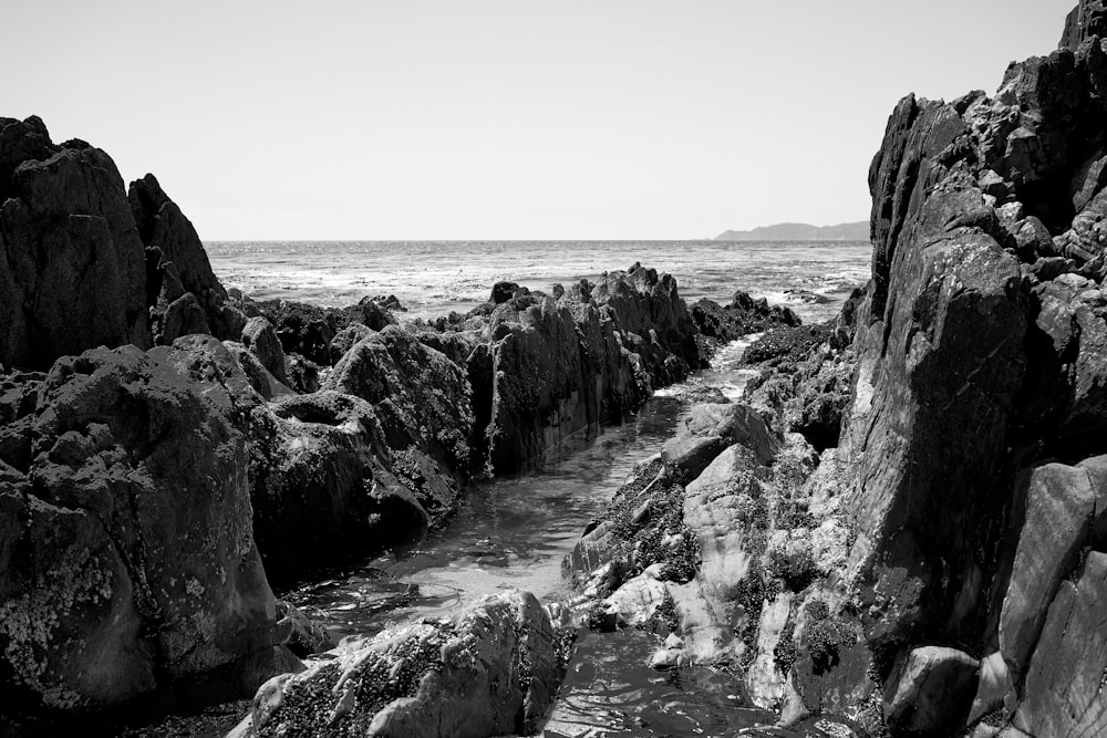 a black and white photo of rocks and water