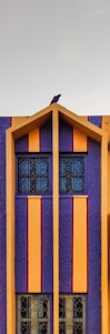 A vibrant vertical print on a modern home facade blending futuristic design with natural surroundings.