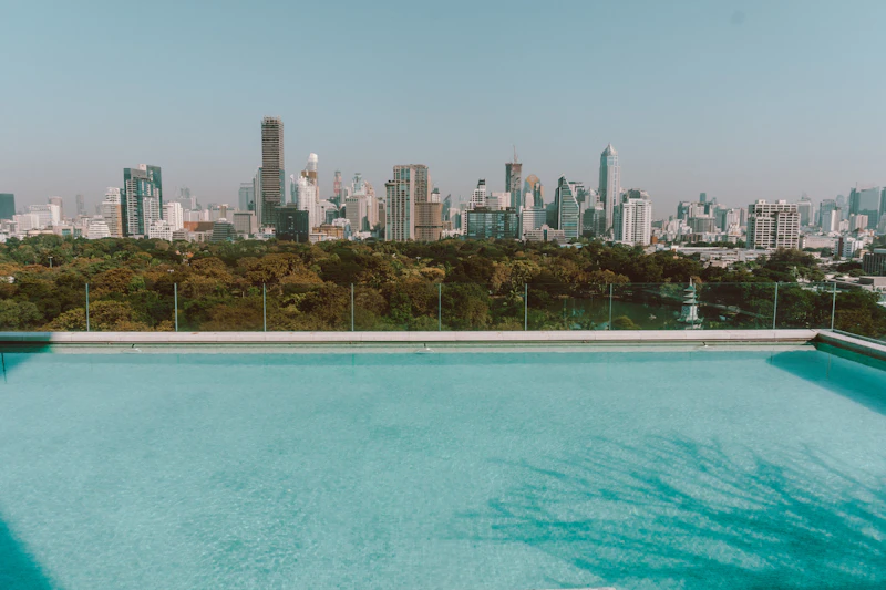 Piscina infinita en la azotea de un edificio con el perfil de rascacielos de Bangkok al fondo