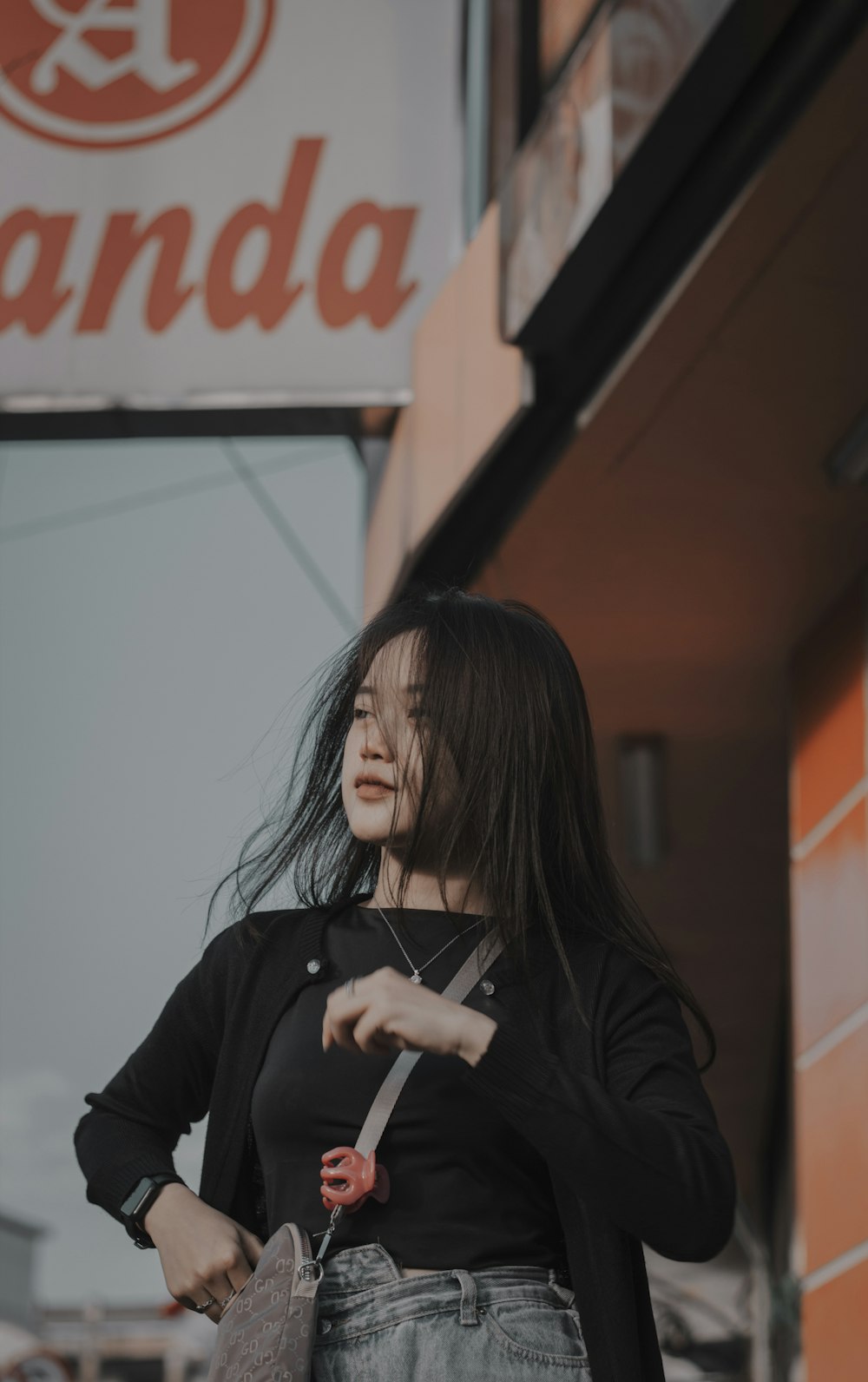 a woman standing outside of a store holding a purse