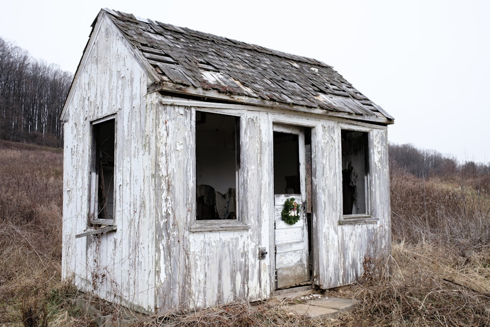 an old outhouse with a wreath on the door