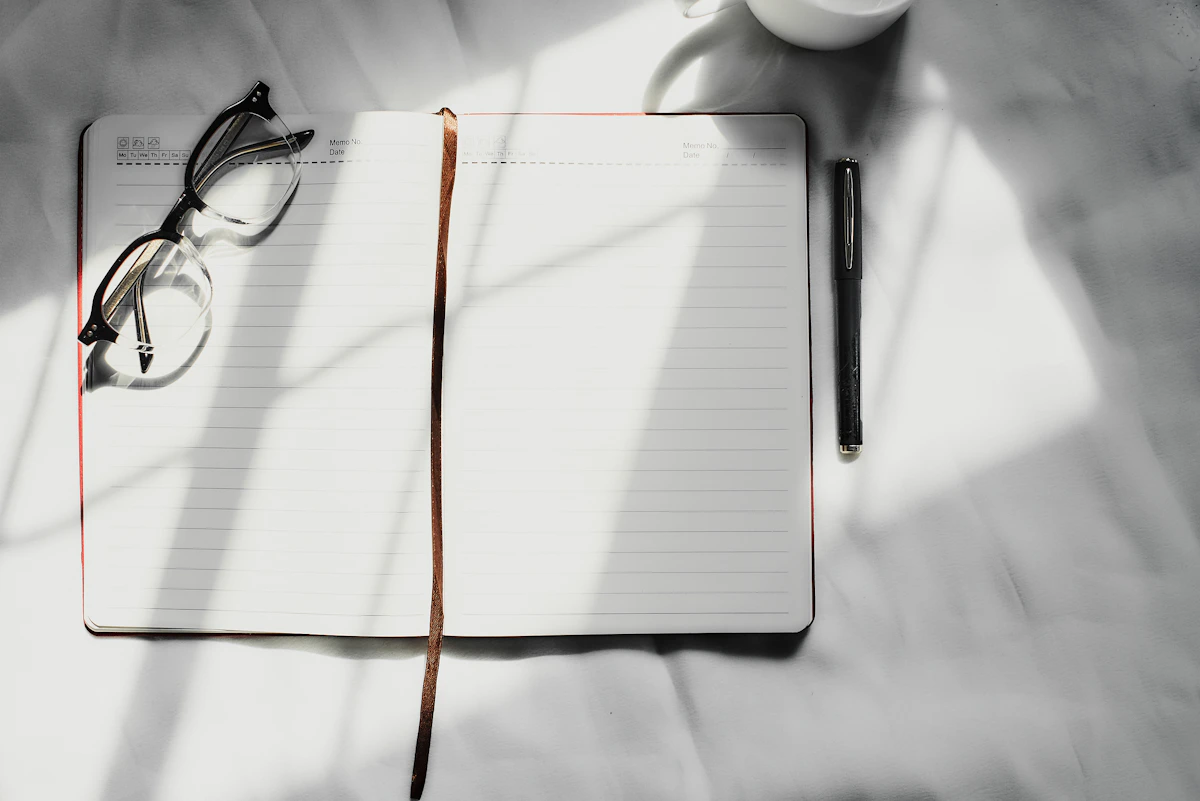 Open notebook and pen on a clean desk for a simple weekly planning reset