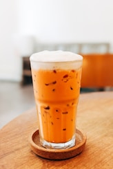 a glass of liquid sitting on top of a wooden table