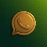 A gold-colored 3D icon of a phone symbol enclosed within a chat bubble on a gradient green background.