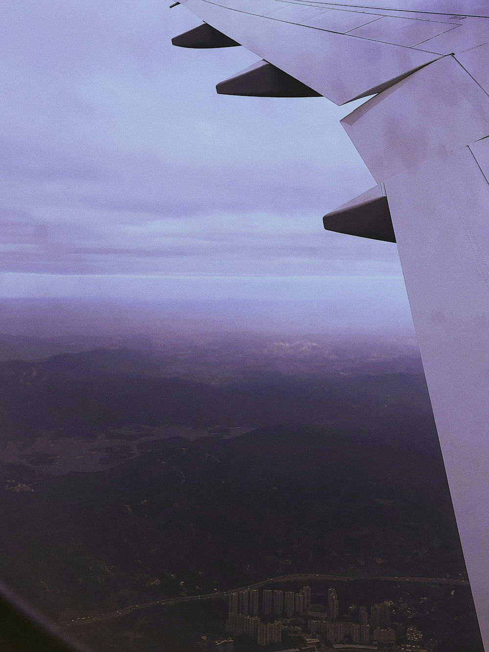 the wing of an airplane flying over a city