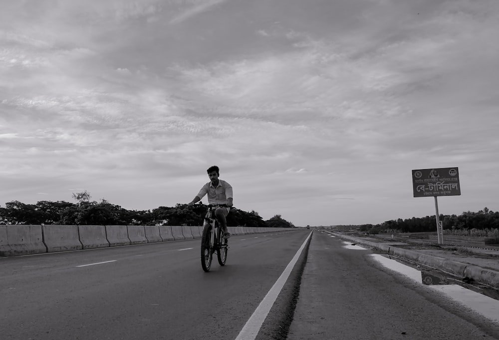 a man riding a bike down the middle of a road