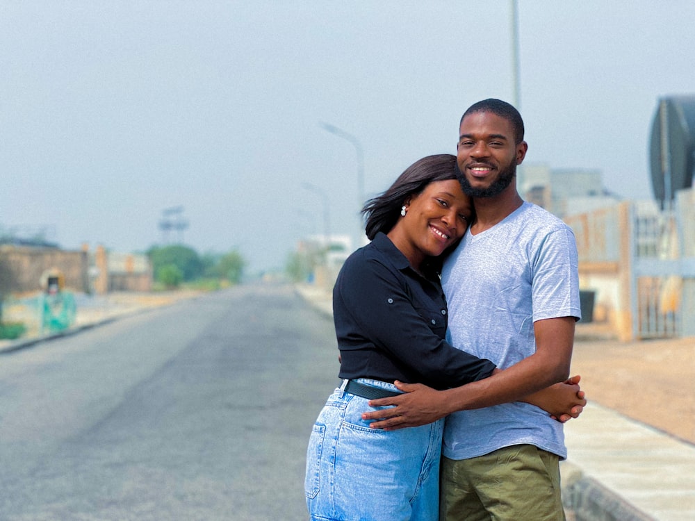 a man and a woman hugging on the side of a road