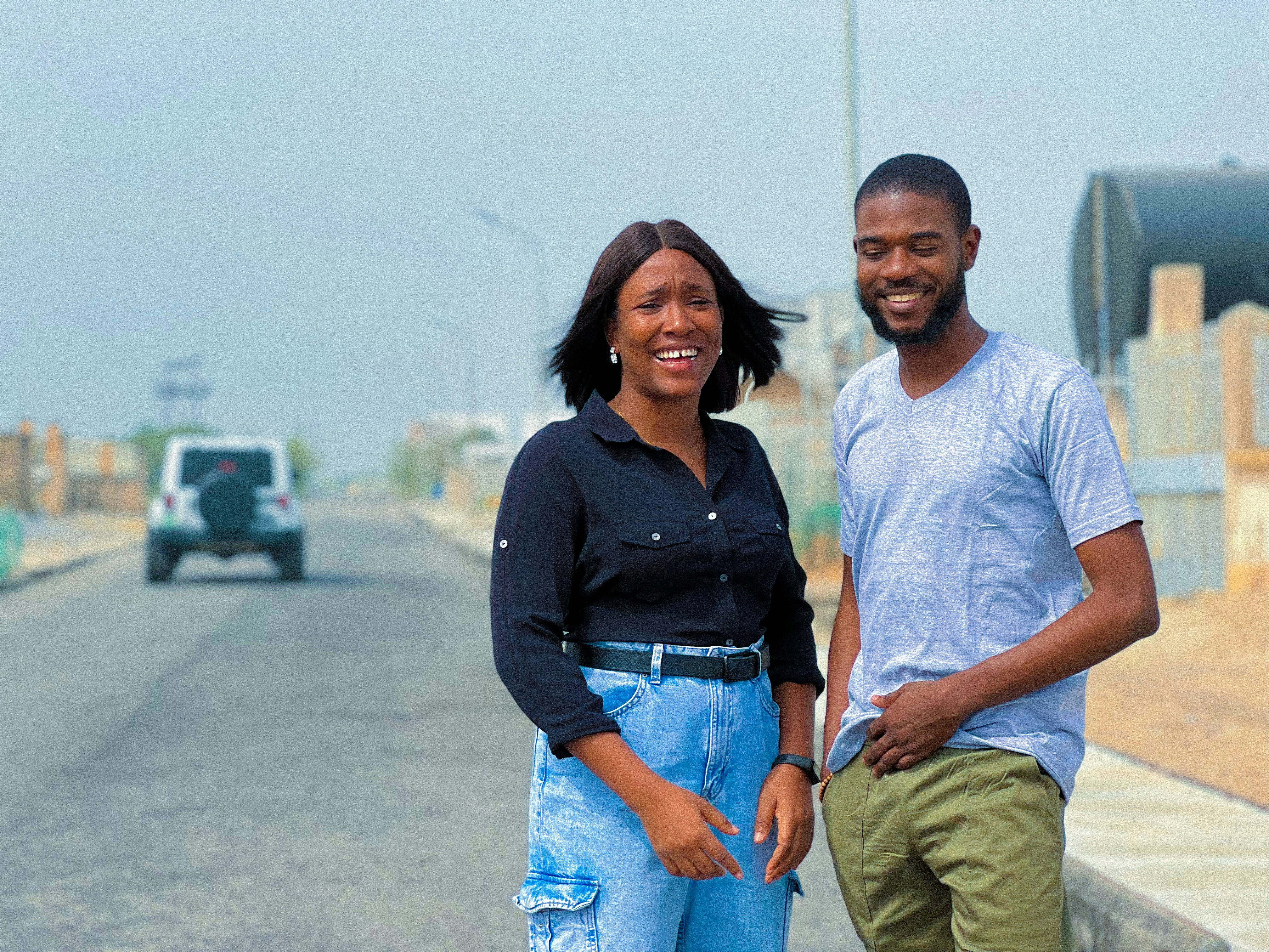a man and a woman standing on the side of a road
