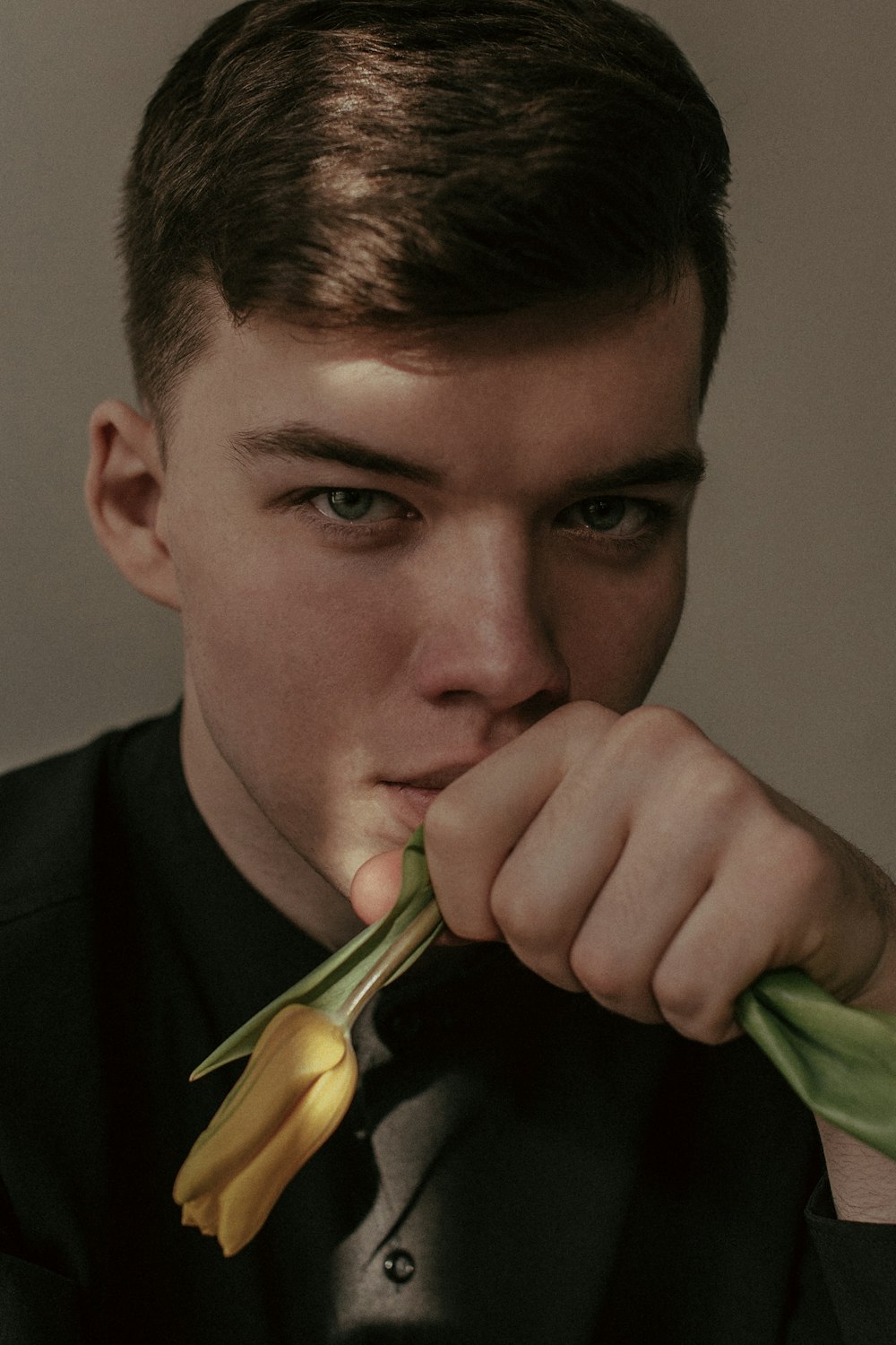 a young man holding a flower in his mouth