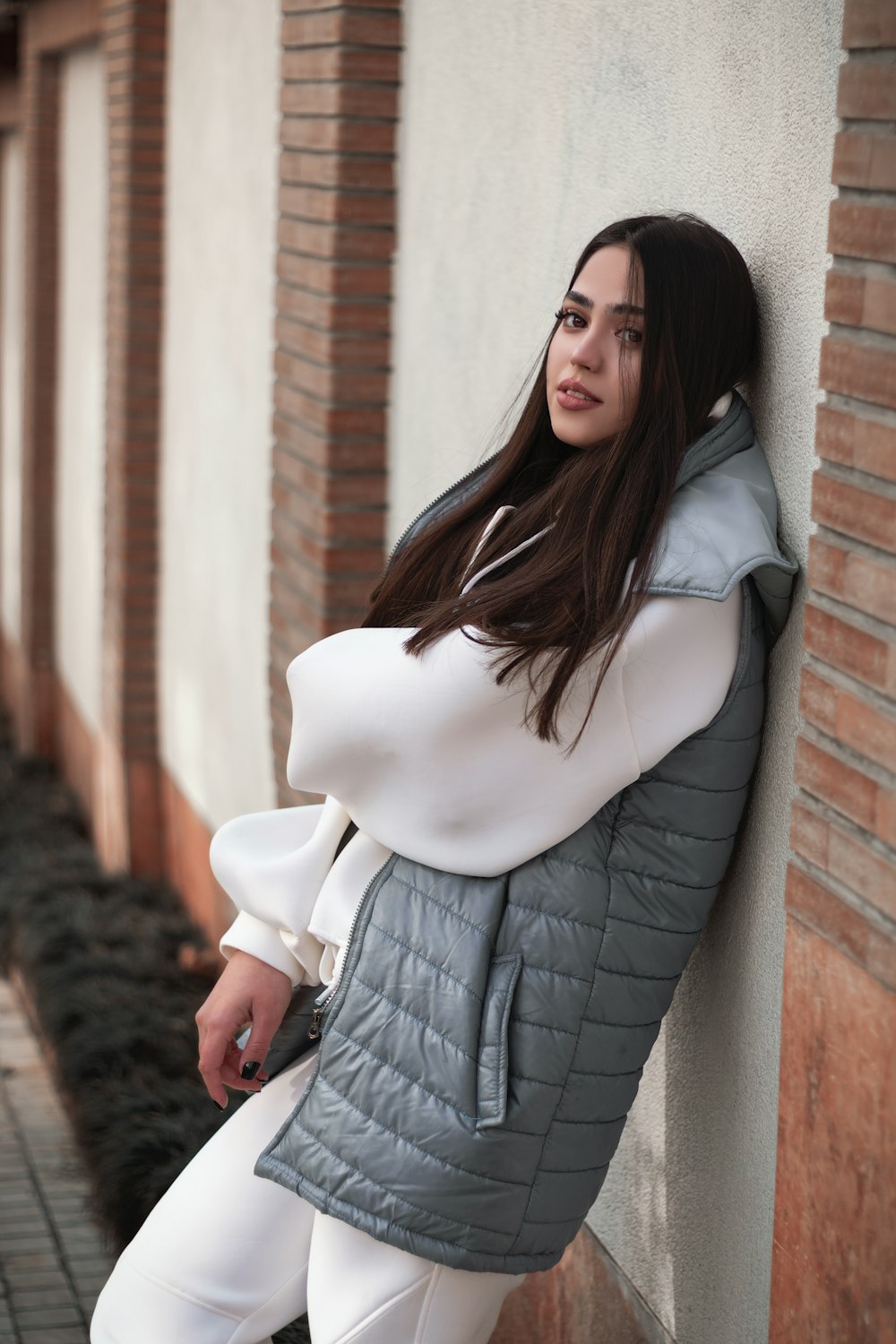 a woman standing in front of a brick building