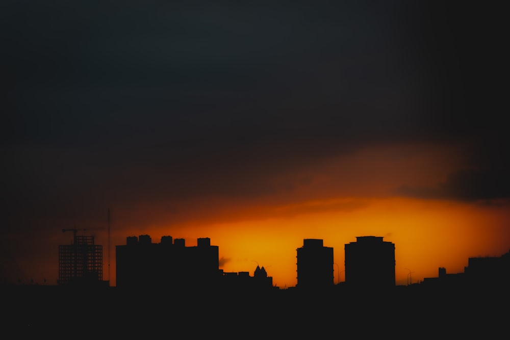 the sun is setting over a city with tall buildings