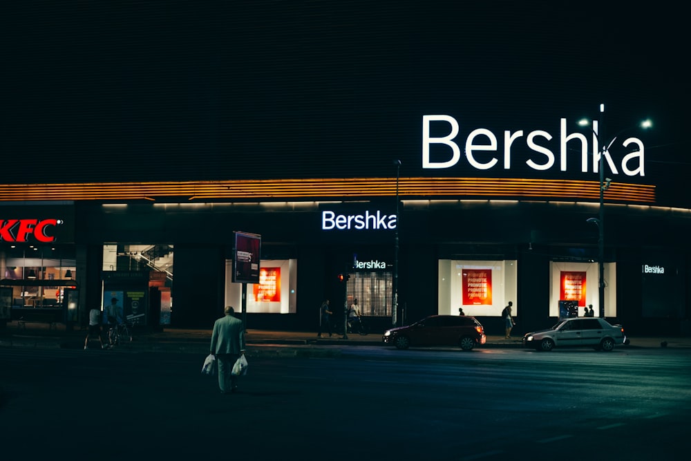 a person walking across a street at night