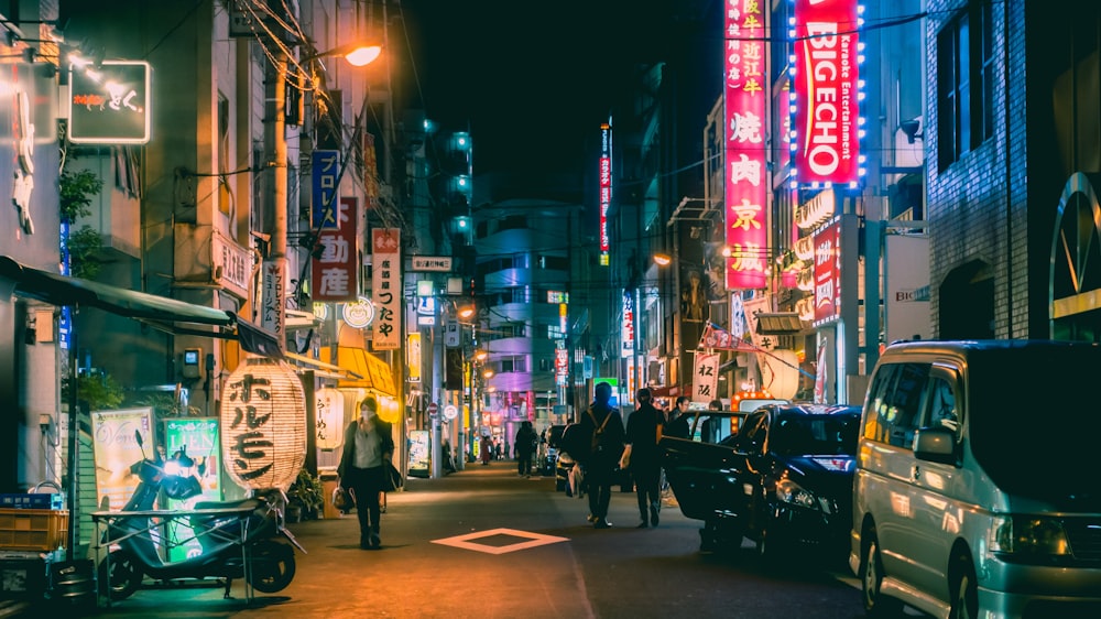 a busy city street at night with neon signs