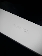 Close-up of a sleek, branded packaging box with a minimalist logo embossed on the surface.