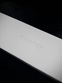 Close-up of a sleek, branded packaging box with a minimalist logo embossed on the surface.
