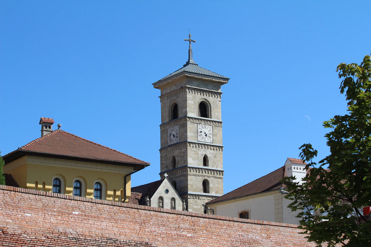 Cazare în Alba Iulia: turn cu ceas deasupra acoperișurilor din cetate