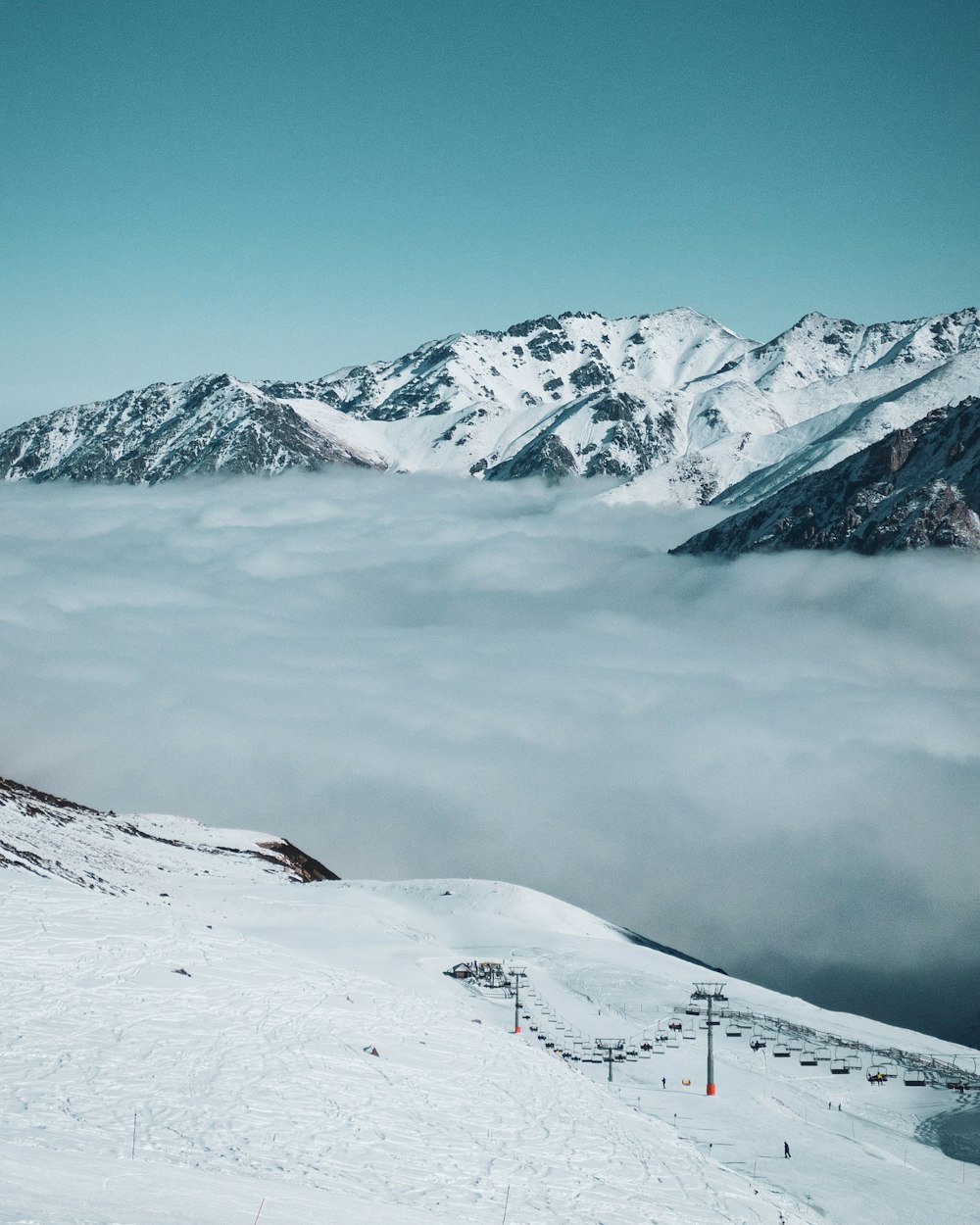 a snowy mountain with a ski lift in the foreground