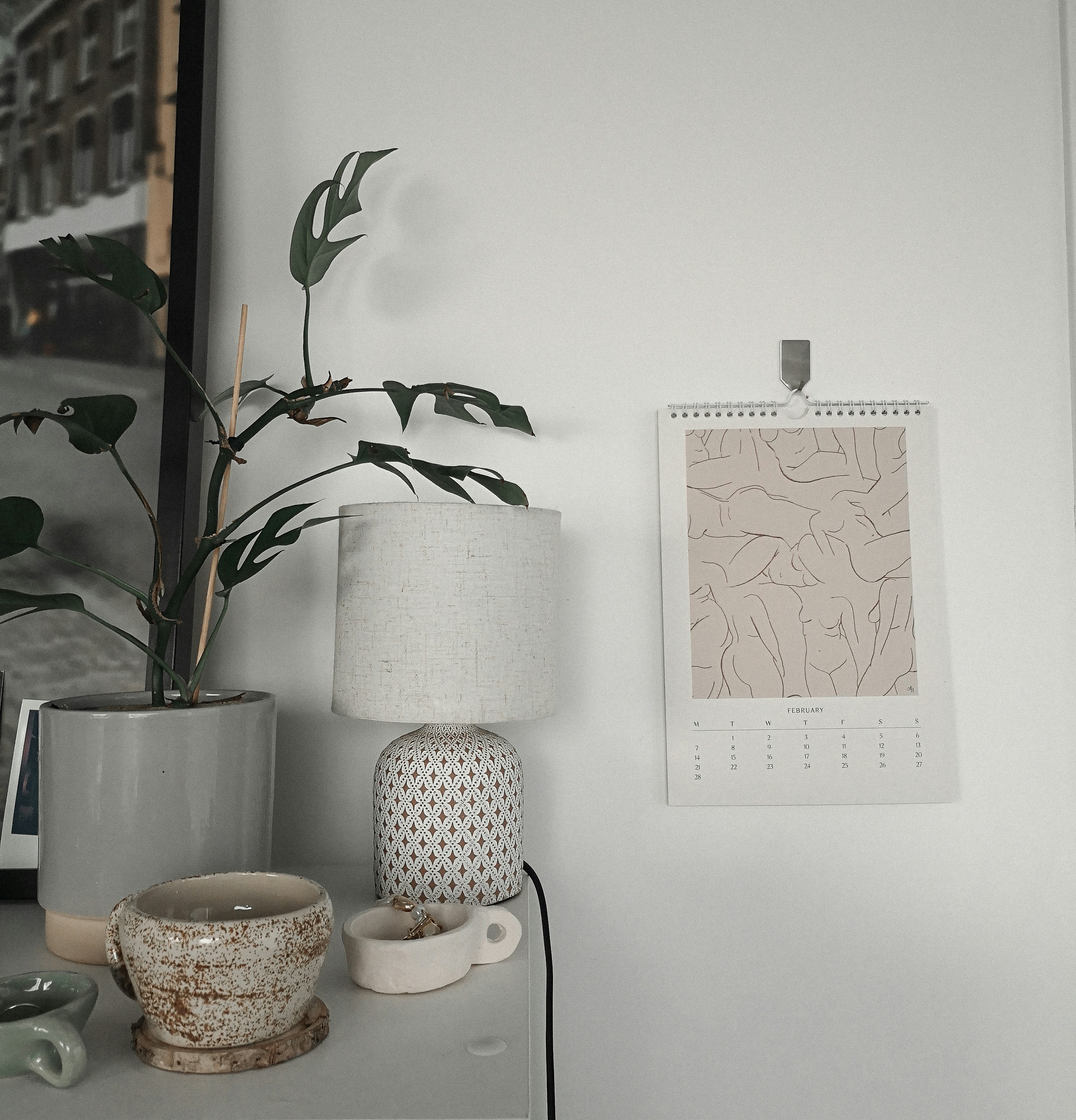 a white table topped with a lamp next to a potted plant