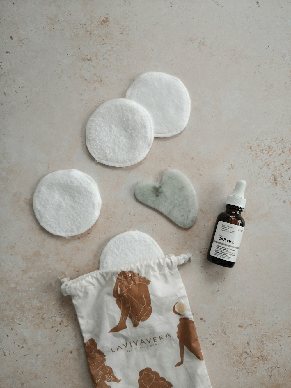 a bottle of essential oils next to a small pouch