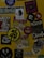 A collection of various stickers arranged on a yellow surface. The stickers include images of a woman, abstract designs, brand logos, and cartoon characters, along with text in different fonts.