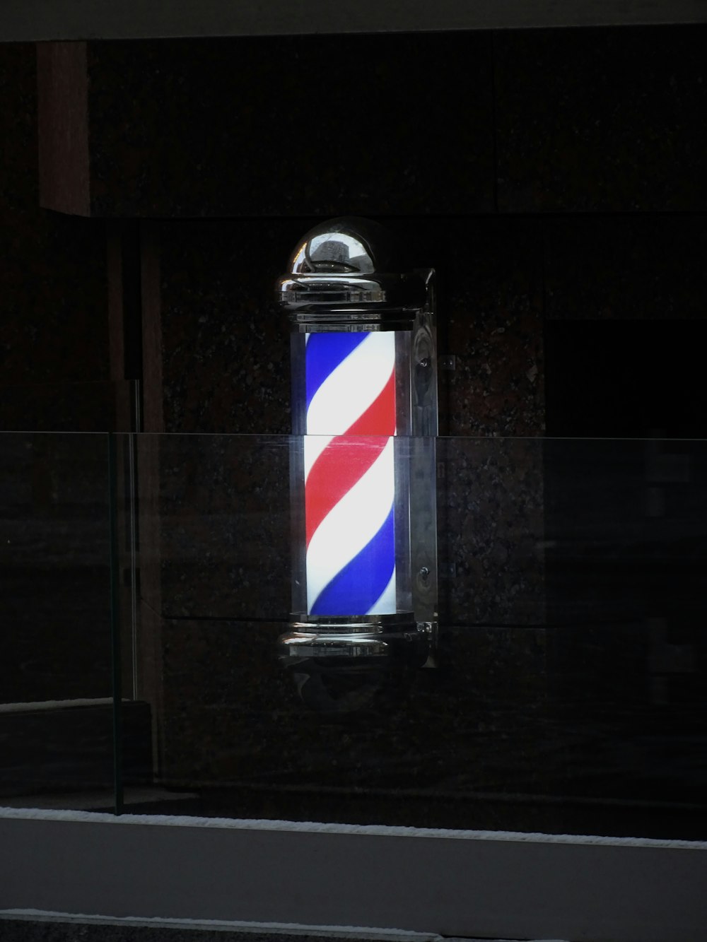 a barber shop sign with a red, white, and blue stripe on it