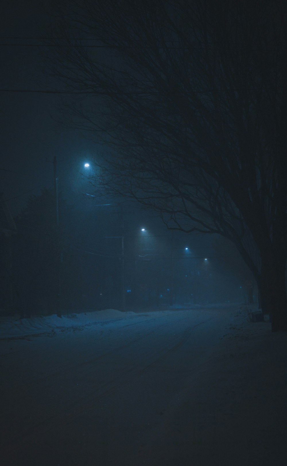 Una calle oscura por la noche con luces de la calle