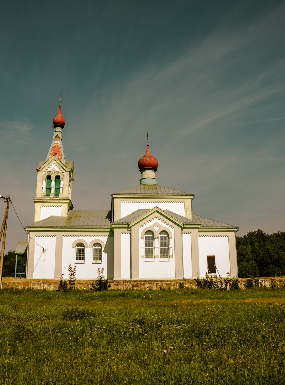 a white and green church with two towers