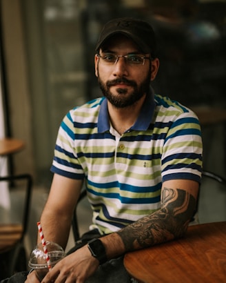a man sitting at a table with a drink in his hand