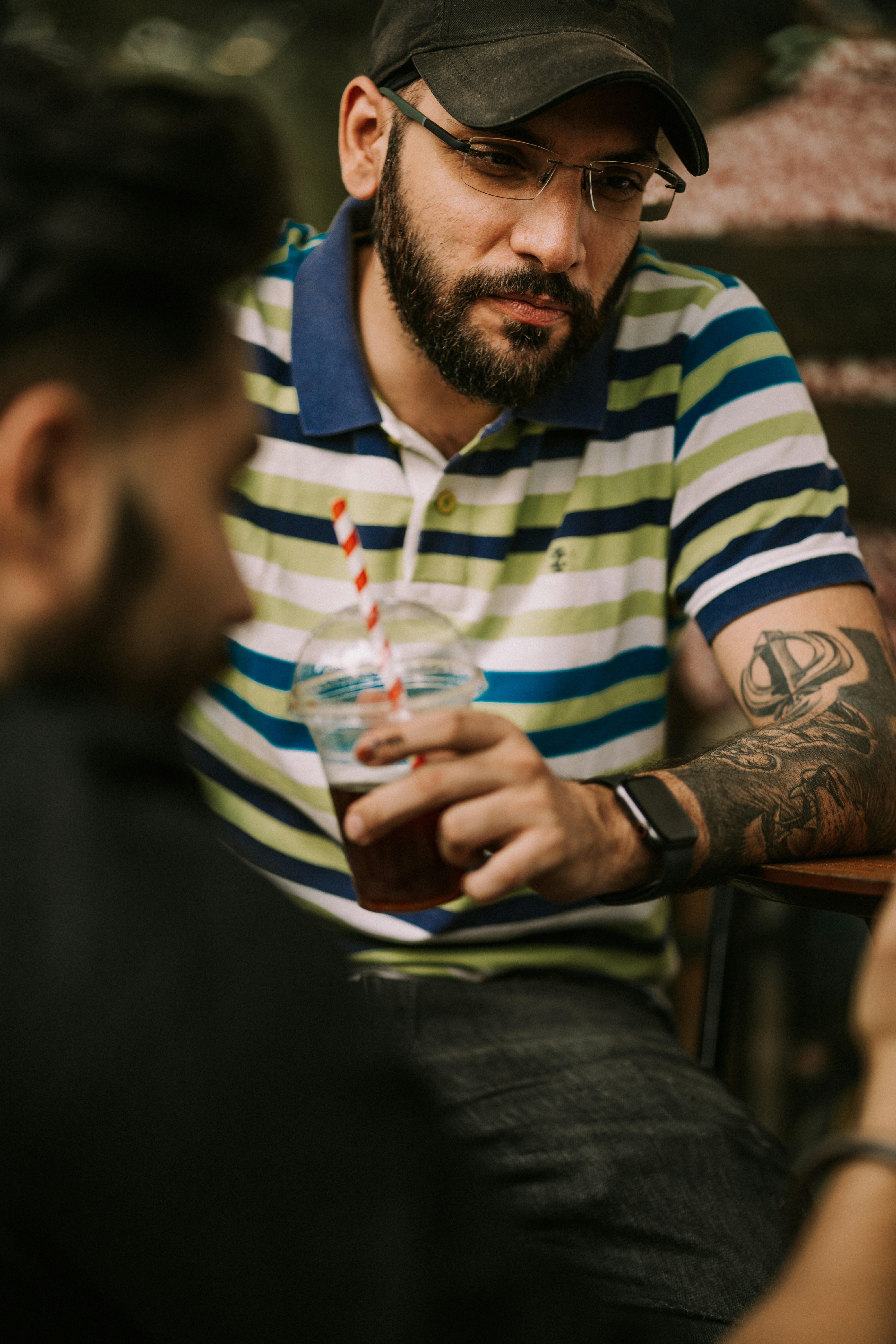 a man sitting at a table with a drink in his hand