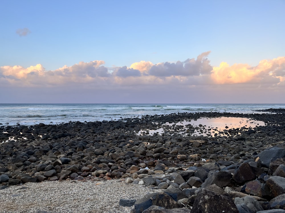 a rocky beach with a body of water in the distance