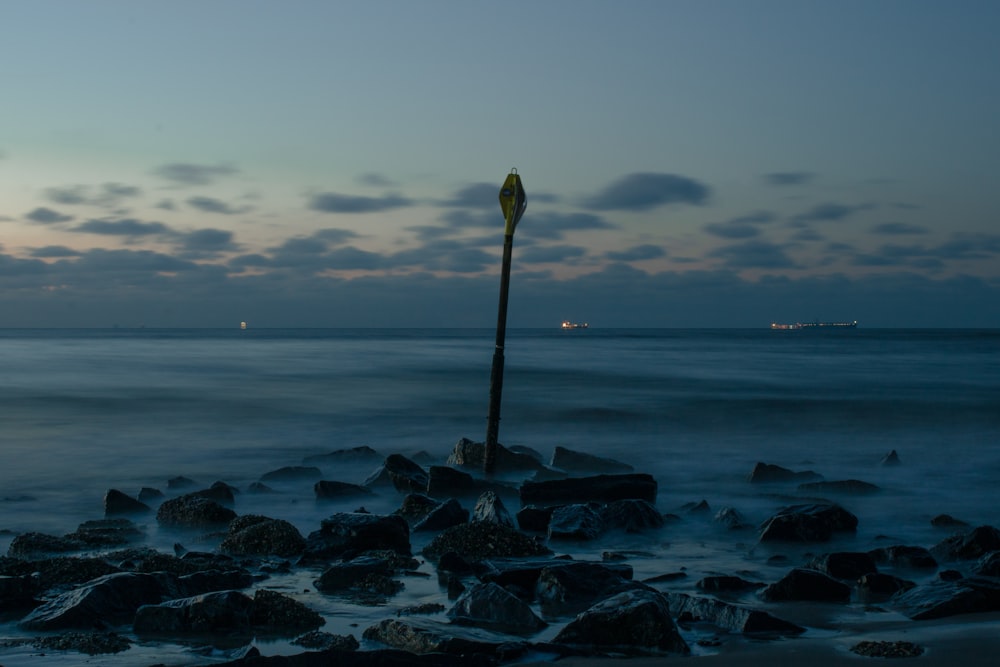 a street light sitting on top of a rocky beach