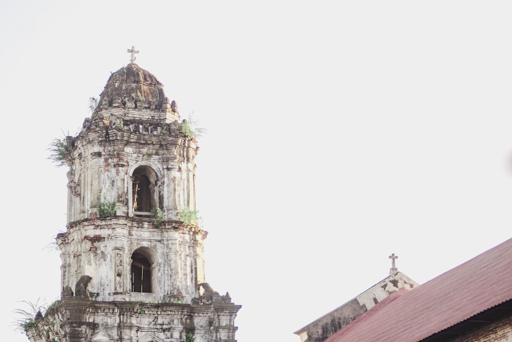 una torre alta con una cruz encima