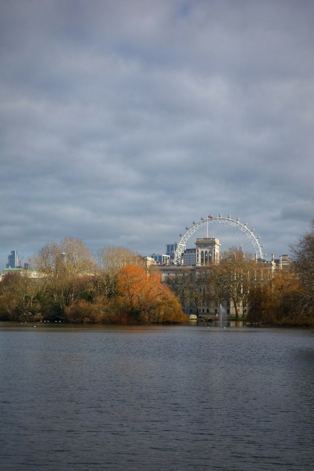 a large body of water with a ferris wheel in the background