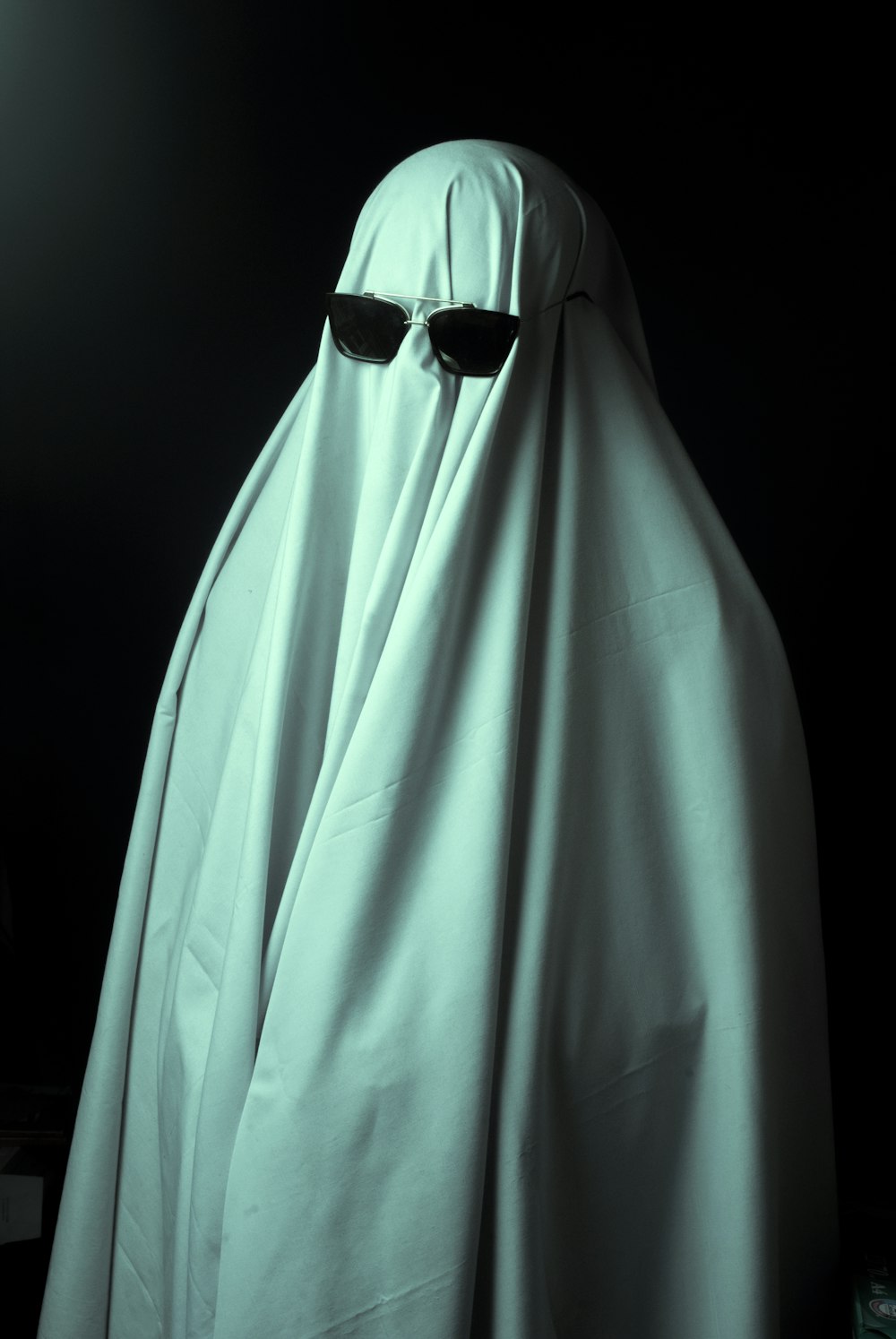 a person in a white cloak and sunglasses