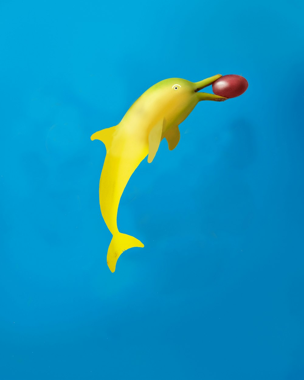 a yellow plastic dolphin floating in the air