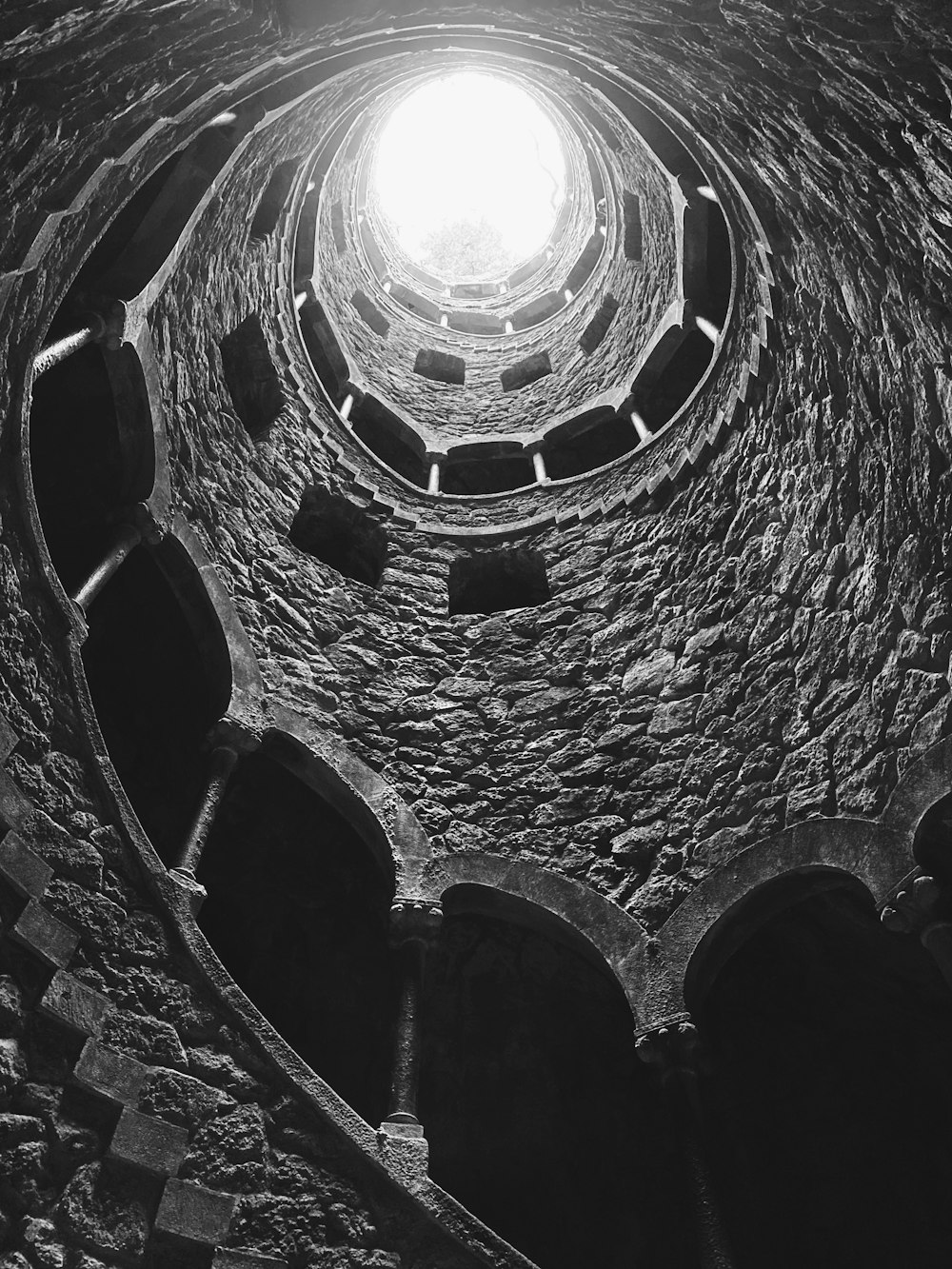 a black and white photo of a spiral staircase