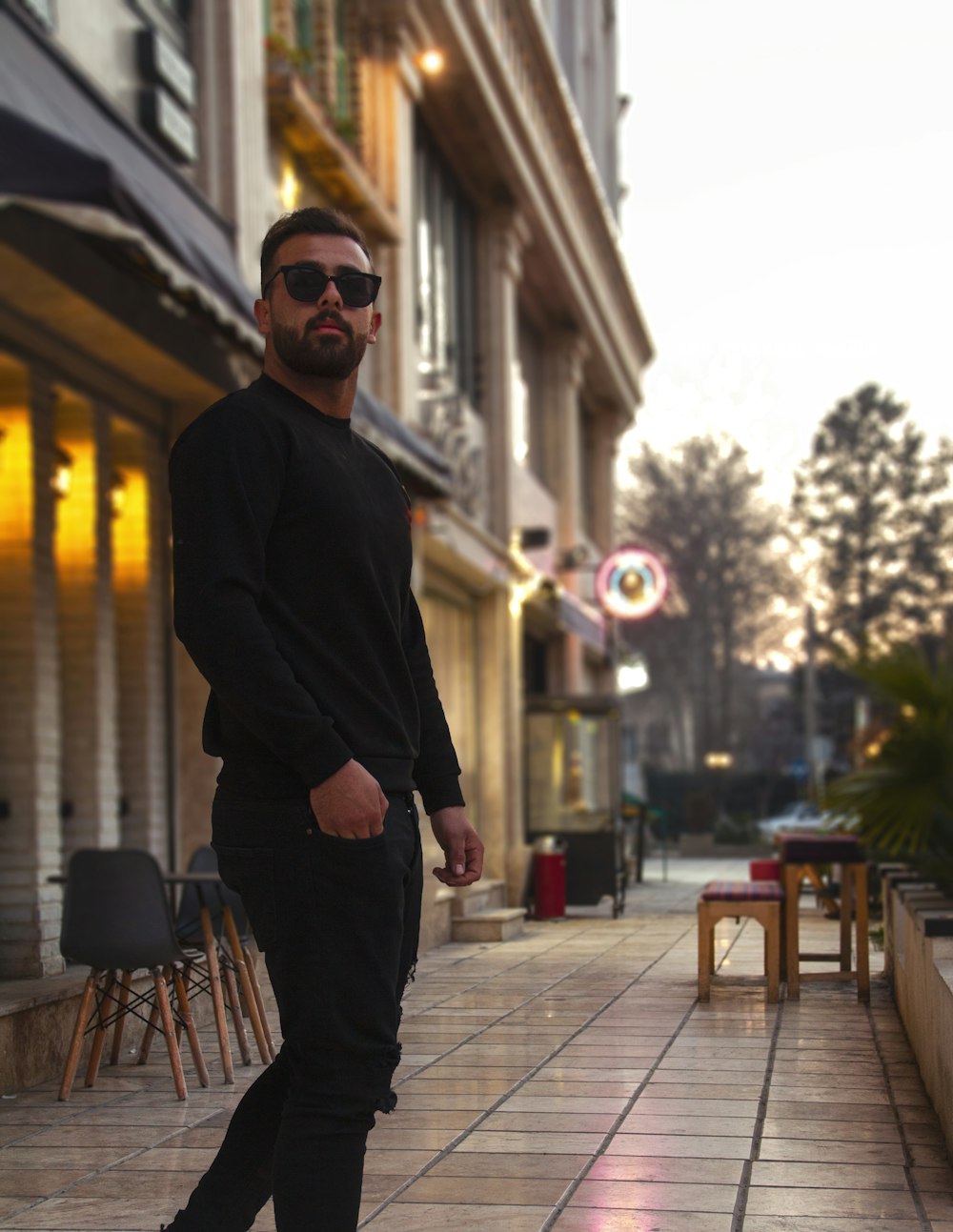 a man standing on a sidewalk in front of a building