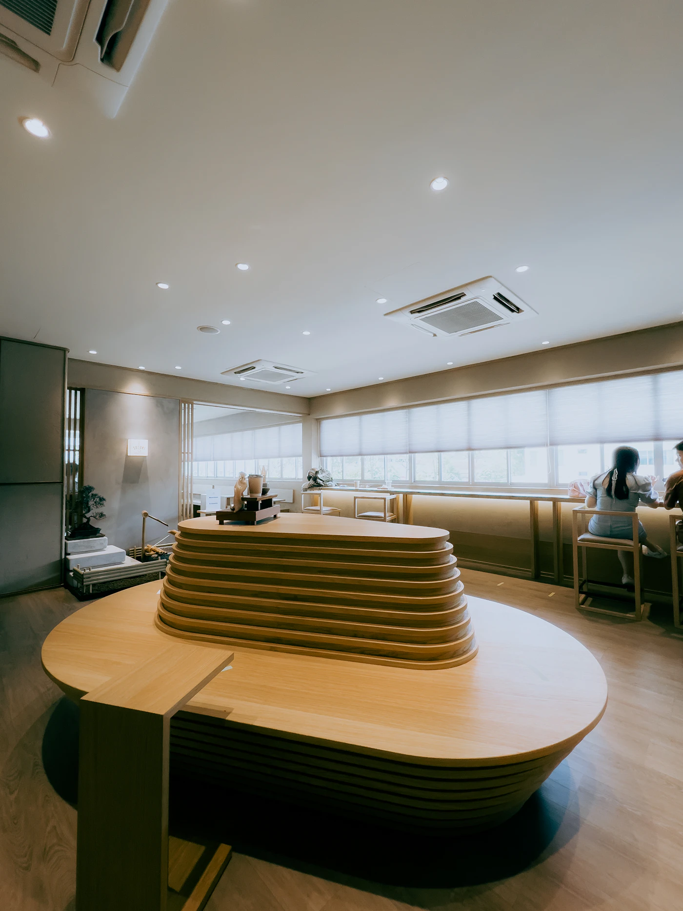 A long curved wooden counter in a bright, quiet room