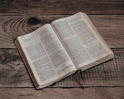 an open book sitting on top of a wooden table