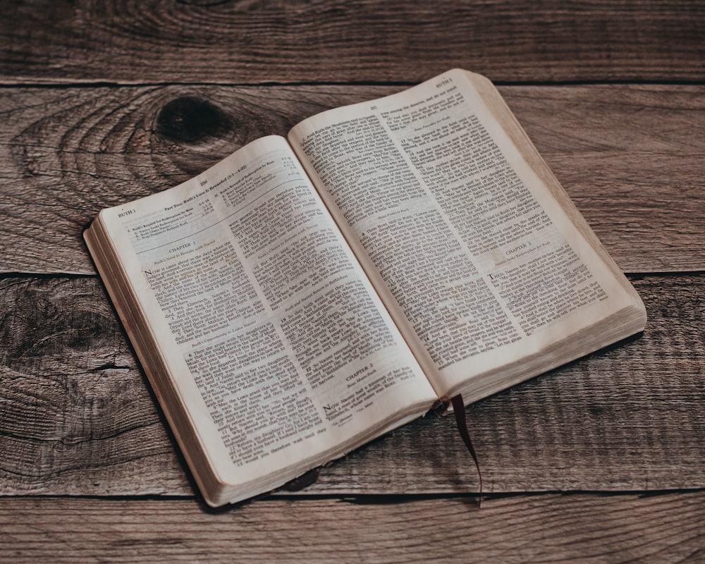 an open book sitting on top of a wooden table