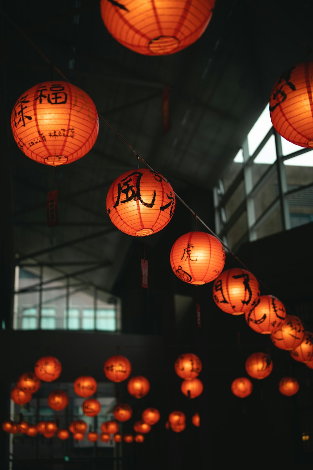 a room filled with lots of paper lanterns hanging from the ceiling