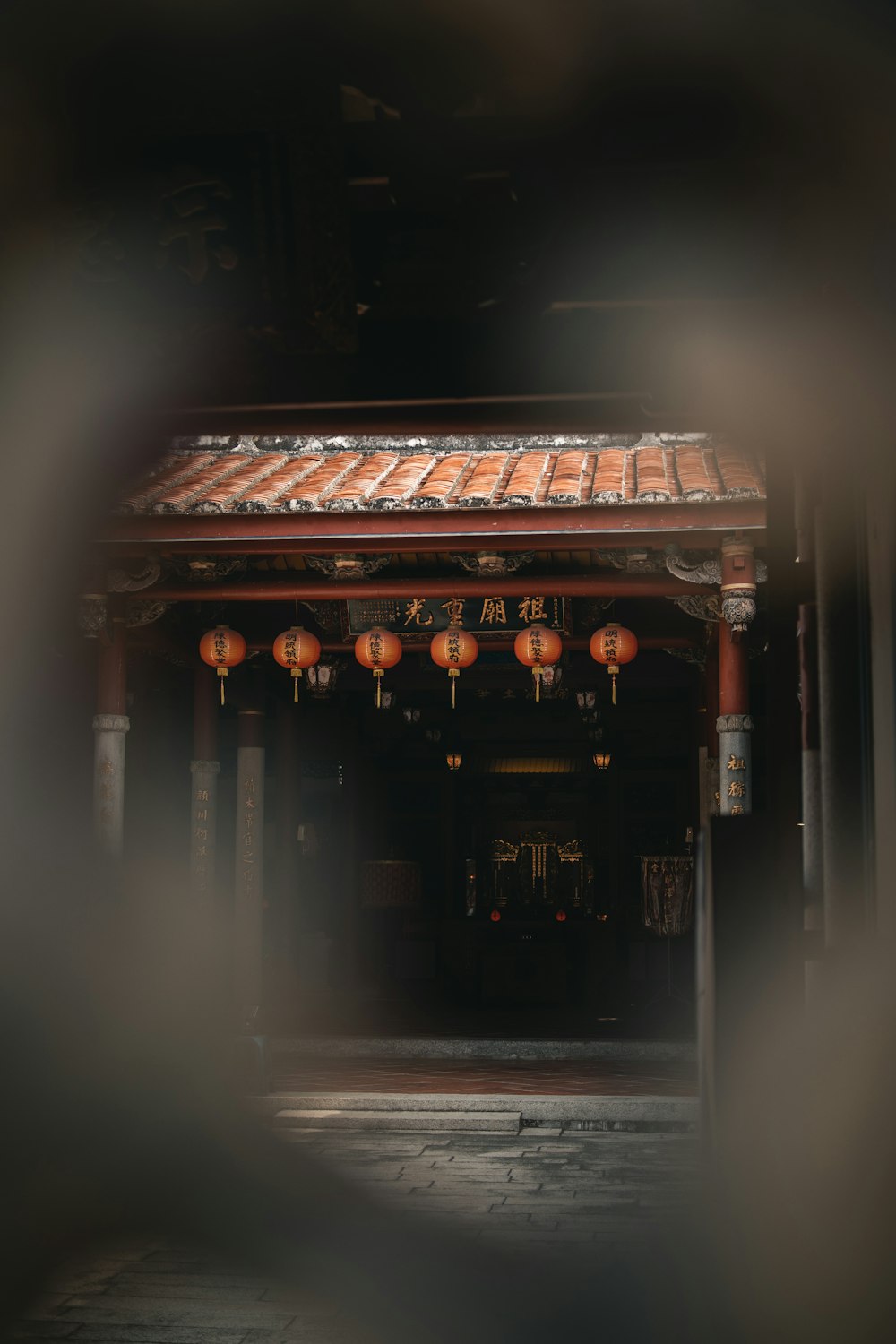 a building with lanterns hanging from it's roof