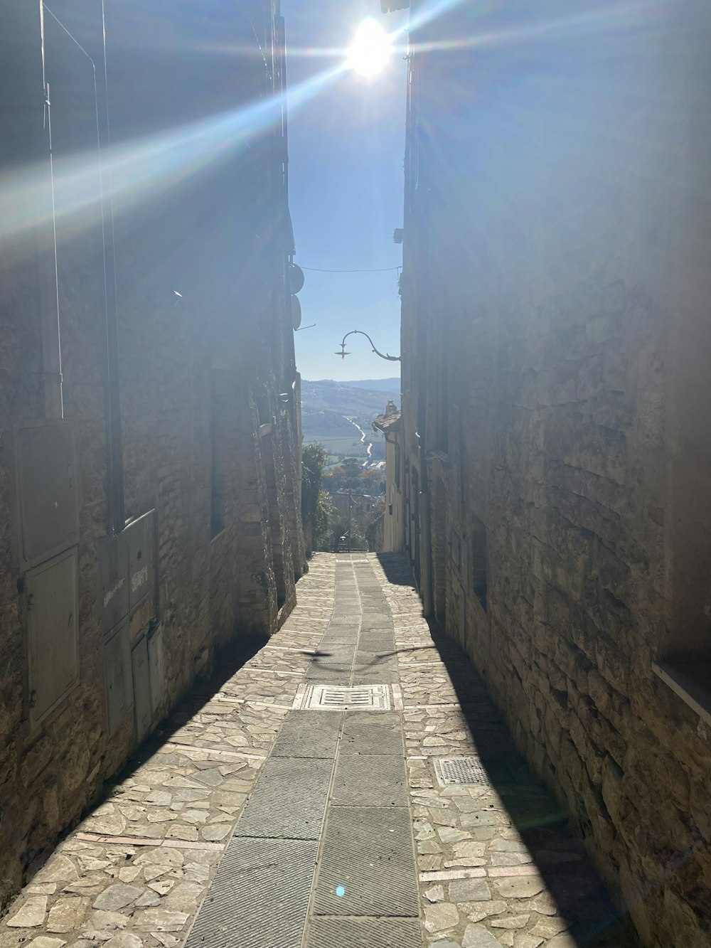 the sun is shining down on a cobblestone street