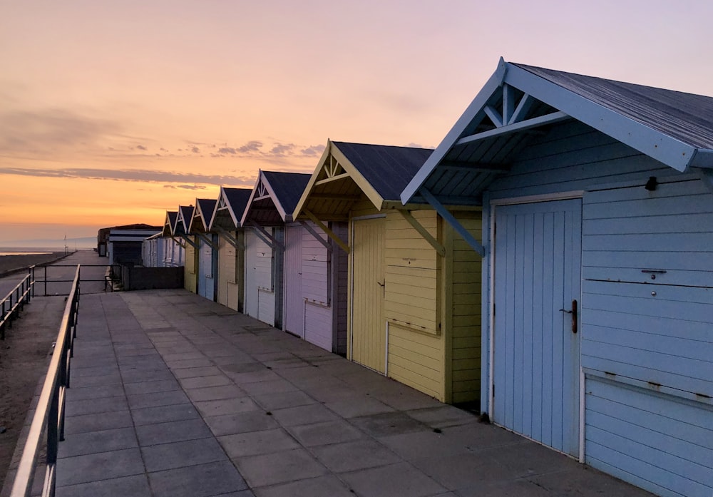 a row of beach huts next to the ocean