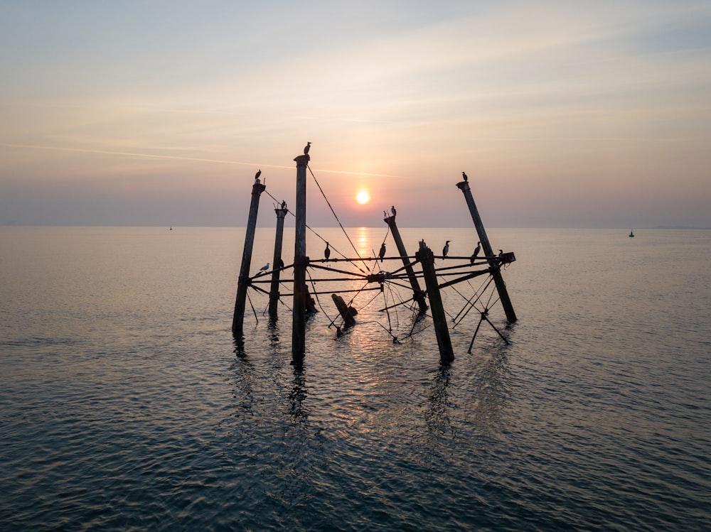 El sol se está poniendo sobre el océano con una red de pesca en el agua