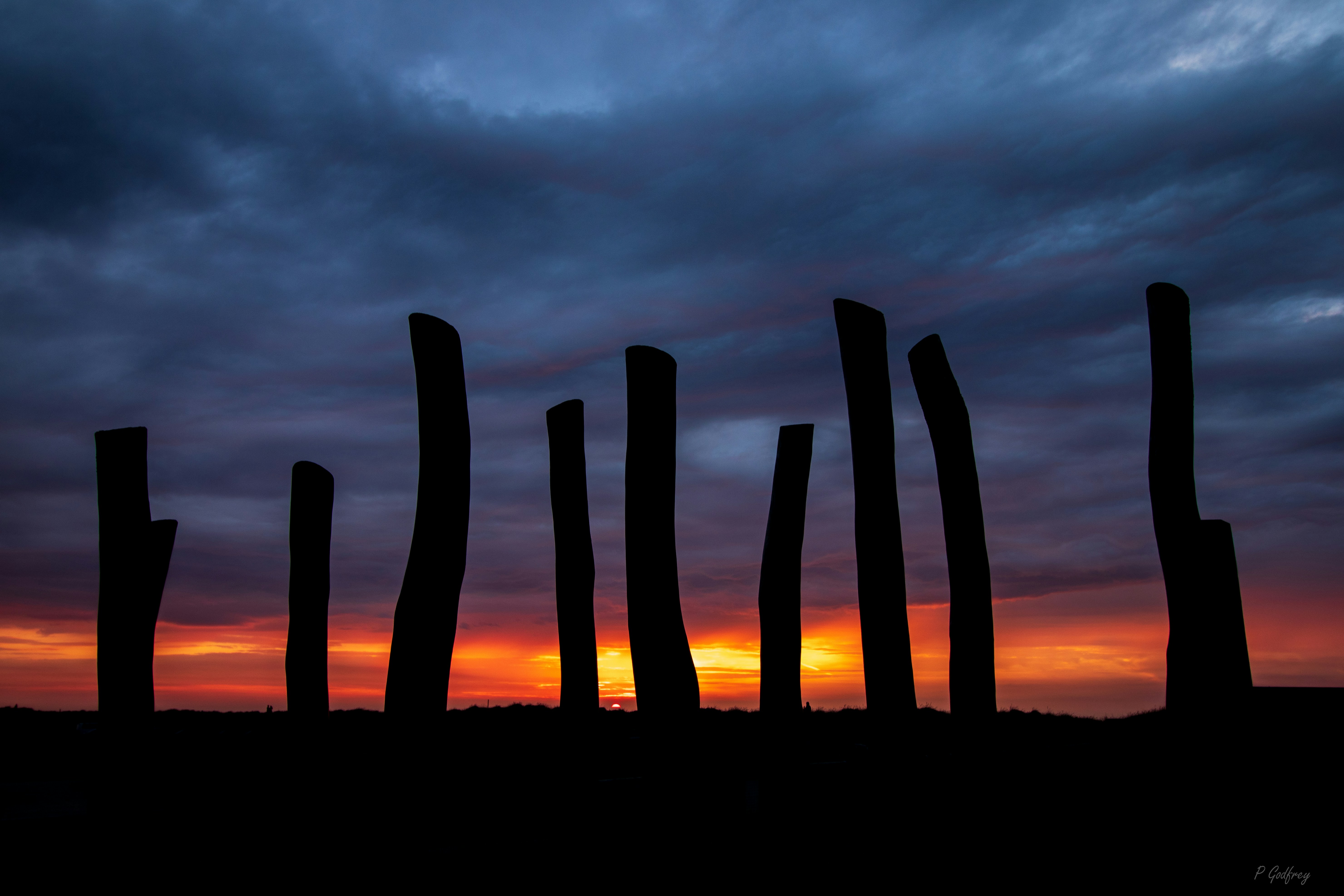 a group of wooden posts sitting in the middle of a field